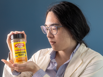 Portrait of Michael, gazing at a container of nutritional yeast